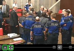 Entouré par les policiers, le trublion a dû quitter la salle du Grand Conseil. DR 