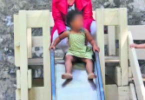 Esther Alder, conseillère administrative, joue avec un enfant sur un tobbogan du parc des Bastions; un jeu bientôt changé. 