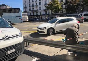 Sur la place Dorcière, une voyageuse attend son bus assise sur la glissière de sécurité. DR