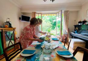 Le personnel dresse la table du repas qui sera partagé avec les résidents «comme à la maison». En médaillon, Sabine Murbach, directrice de la Maison de Tara. MP