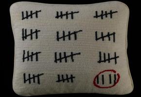 Un coussin à motif  de calendrier de prisonnier  créé par Adrian Anthony Gill.