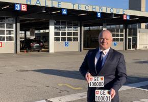 Didier Leibzig, directeur de l’Office cantonal des véhicules, présente les deux plaques d’immatriculation à six chiffres pour motos mises en vente. DR