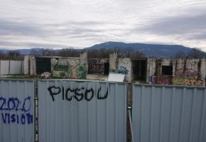 Le bâtiment couvert de tags est entouré de barrières en tôle. MP