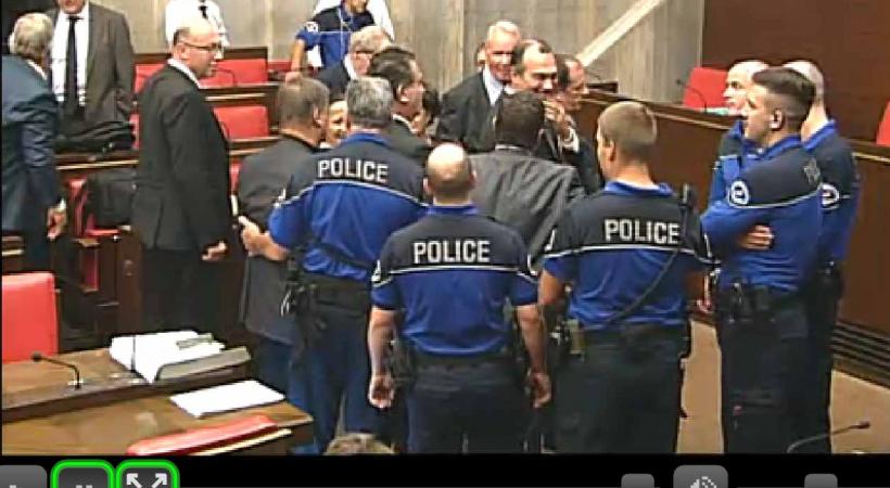 Entouré par les policiers, le trublion a dû quitter la salle du Grand Conseil. DR 
