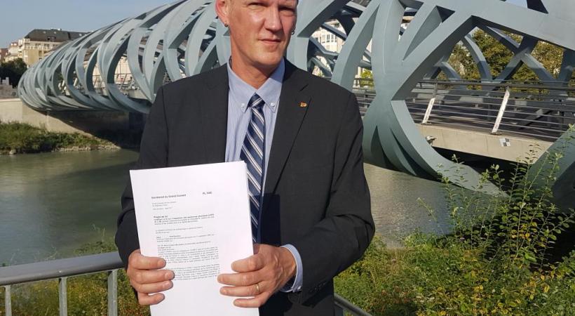 Le député Stéphane Florey tenant le texte du projet de loi. DR 