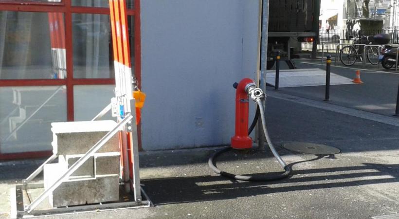 La photo prise le soir par le commerçant (en médaillon) montre la puissance du jet et un tuyau situé à côté de l’hydrante. DR 
