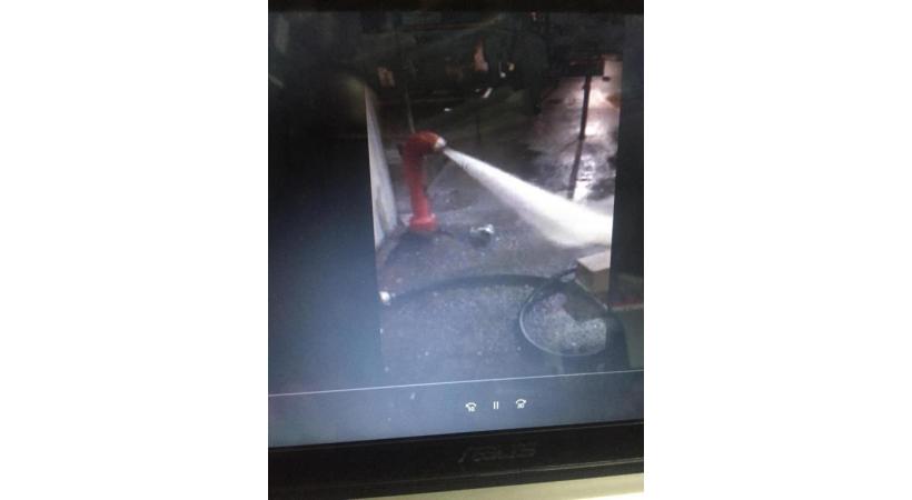 La photo prise le soir par le commerçant (en médaillon) montre la puissance du jet et un tuyau situé à côté de l’hydrante. DR 